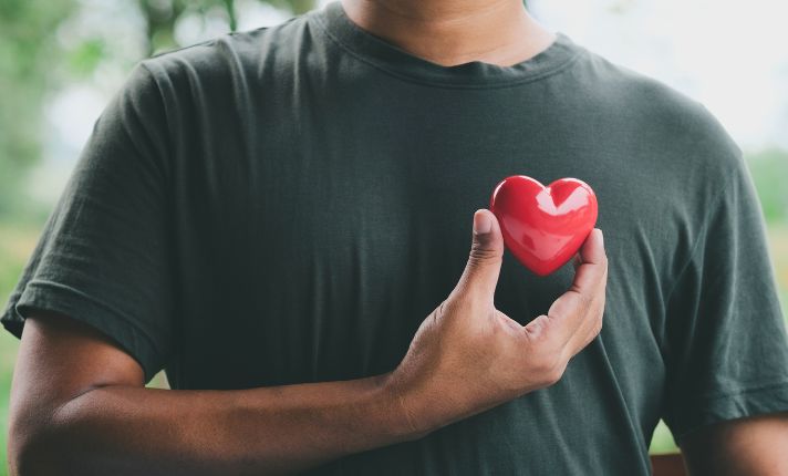 A man is holding a heart up to his chest in rural arizona.
